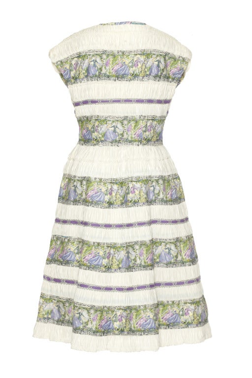 This charming and unusual continental cotton 1950’s dress is one of a kind and made up of different sections that form an overall striped effect.  The multicoloured band depicts a music themed pattern with musical notes, people dancing and playing