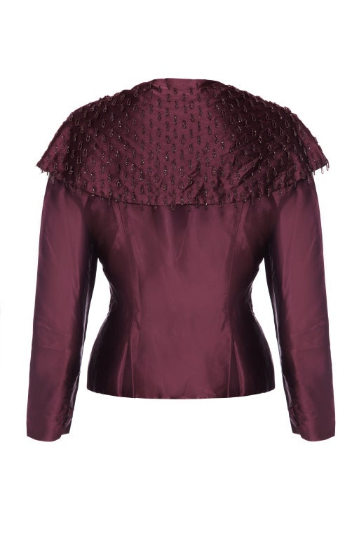 A really beautiful fitted maroon silk jacket featuring an oversized collar covered in maroon beaded loops.  The jacket fastens at the centre front with lovely covered buttons and corresponding buttons at the cuff.  There are two poppers on the