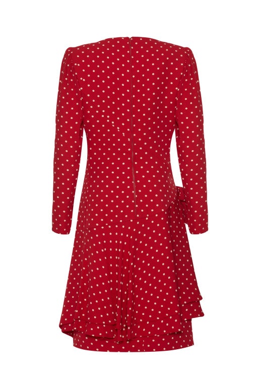 This 1980's red polka dot long sleeved Valentino couture dress is in a beautiful weighted silk.  Movement is created with asymmetric panels and several layers to the hem which creates a sophisticated bias cut.  The dress is 1940's in style with a