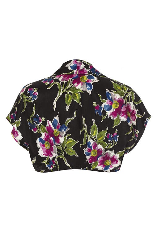 Gorgeous short sleeved acetate bolero style jacket with wide lapels from the late 1930's or early 1940's.  The jacket is black with French blue and fuchsia coloured flowers and green and yellow leaves.  Parts of the print appear to be hand painted