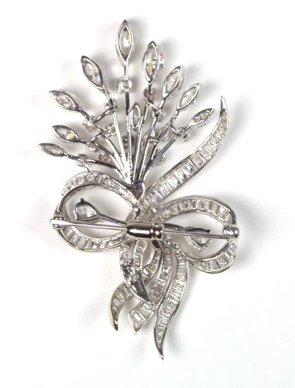The pin contains ninety diamonds, channel- and prong-set, described as:
2 pear brilliant-cut diamonds with average estimated weights of .34 ct. each.
11 graduated marquise brilliant-cut diamonds with estimated weights from .45 to .12 ct. each.
15