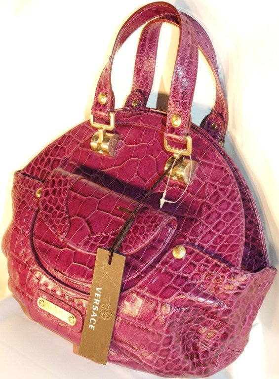 This is a 2008 new with tags Versace purple croc embossed leather 2 handel handbag with kiss flap top opening with multi zipper compartments and two outter flap compartments.  Matte gold hardward and zipper.  Made in Italy.
Measures :
Length