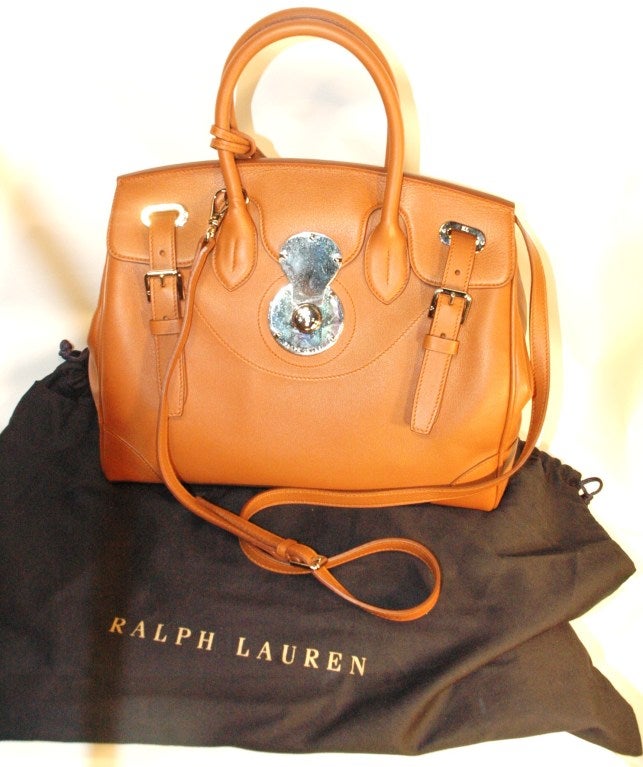 This is a new Ralph Lauren The Ricky soft calf 33 handbag.  Current retail $3500. Never used! Still has protective clear plastic sticker over silver hardware for protection from scratching.  
Inspired by a vintage English Cooper saddle carrier, our