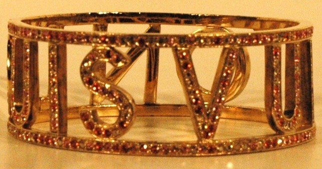 This is a Louis Vuitton 2001 Nuits Bangle Bracelet.  From Louis Vuitton's 2008 Collection, the bracelet is crafted of polished golden metal that is encrusted with shimmering multi-colored Swarovski crystals that come together to form a sparkling,