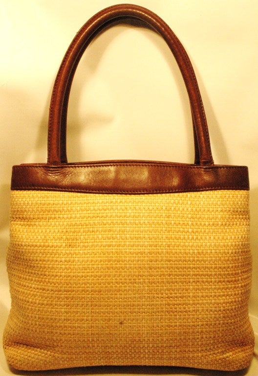 This is a vintage 1990s Chanel raffia handbag with brown leather trim and handles.  Made in Italy.
Measures:
10