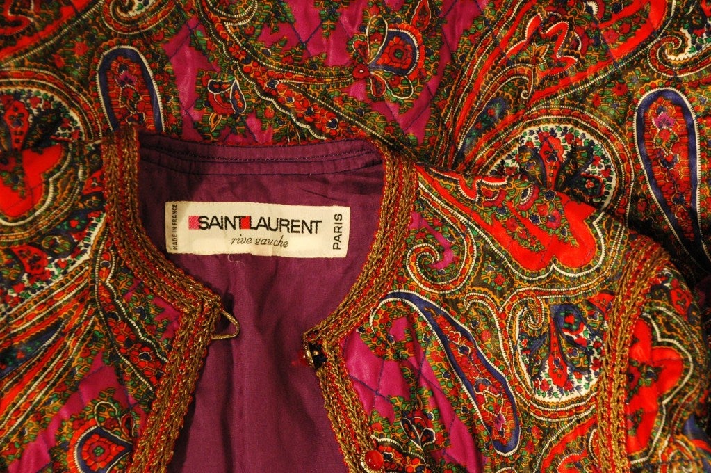 This is a rare vintage Yves Saint Laurent Rive Gauche whimsical diamond quilted silk paisley print long sleeve jacket with 8 ruby red cabochon buttons. Two front pockets, purple silk lining, size 36
Made in France
Measurements:
Bust