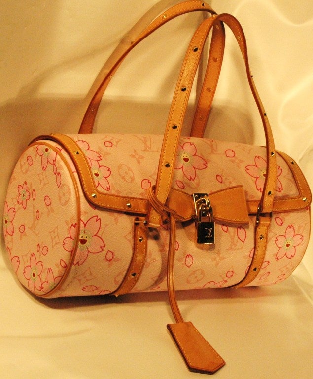 This is a Louis Vuitton Cherry Blossom Papillon in Pink. This chic baguette is created of pink Louis Vuitton monogram on pink canvas with decorative cherry blossoms with smiling faces. The bag features vachetta leather trim and tall top handles with