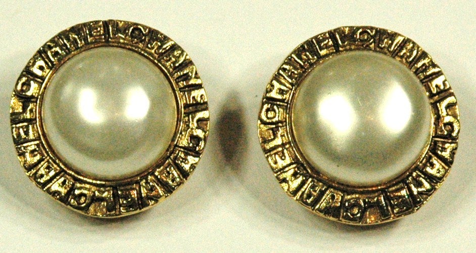 These are a pair of vintage Chanel gold tone button clip on pearl earrings. Made in France. Stamped 3322.