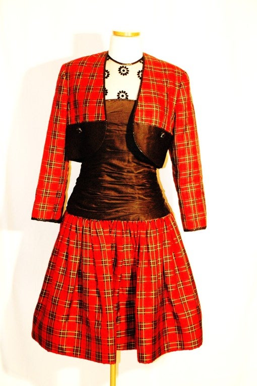 This is a rare 1988 Geoffrey Beene 2 piece Dress and Crop Jacket size 6
Plaid silk skirt and black silk bodice with sheer transparent shoulders with embroidered flowers.
Jacket is quilted and measures 16