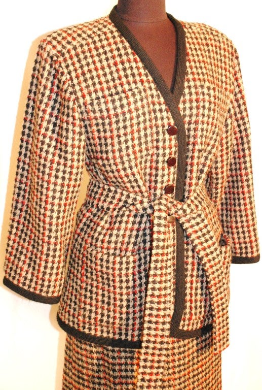 This is a 1984 new with original tags Vintage Yves Saint Laurent suit.  Jacket and skirt with belt.  Plaid red, ivory, & black Size 38 & 40
83% wool
16% mohair
1%  nylon
lining 100% acetate
Jacket size 38 measures:  Bust 34-36, sleeves 22