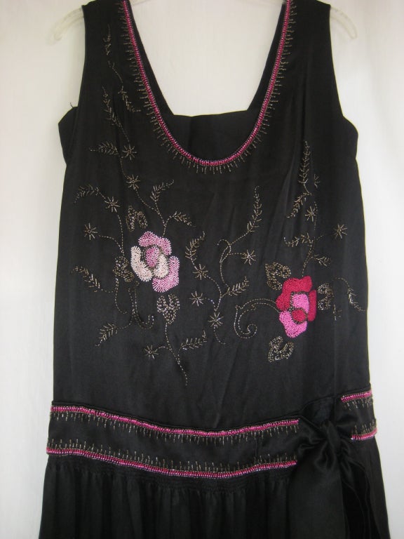 black heavily beaded silk charmeuse flapper dress with velvet band at bodice
silk bow at hips
scalloped hemline
wonderful beaded flowers in shades of pink and rose