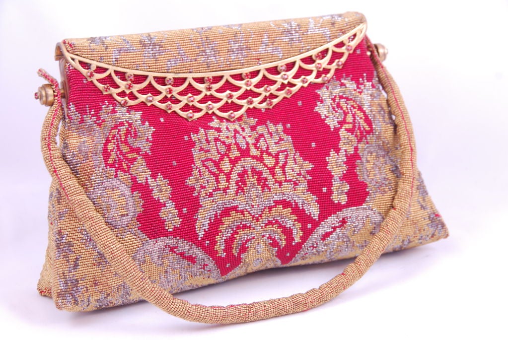 Steel beaded evening bag in red, silver and gold with red rhinestone studded brass frame made in France for the Park Ave. dress shop Martha. In its day, Martha was 