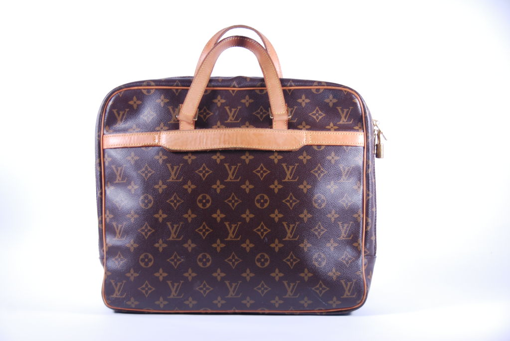 Luis Vuitton briefcase. Handles and trimming are cowhide leather and a wraparound zip for easy access. One interior zipper compartment and several open compartments. Outside has one exterior compartment and the other side has a smaller compartment