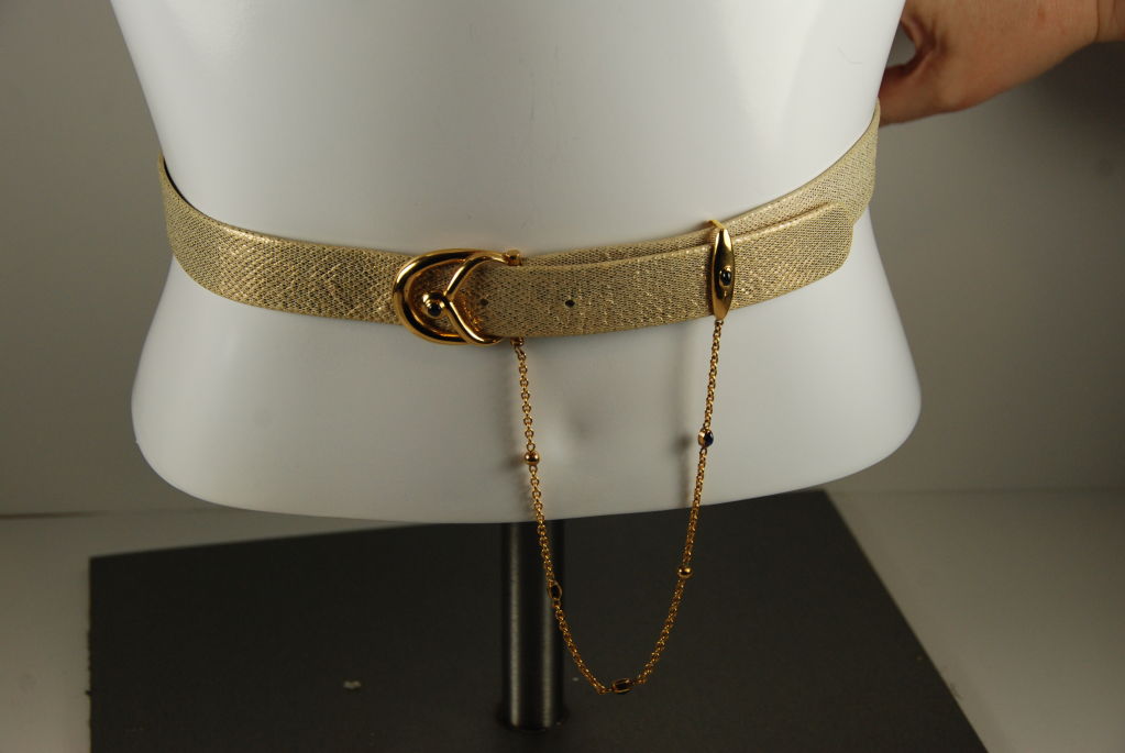 Gold leather belt by Cartier from the 1980's. The leather has a shimmery finish. The stones in the belt are lapis. Belt is adjustable and will a waist of 26.6