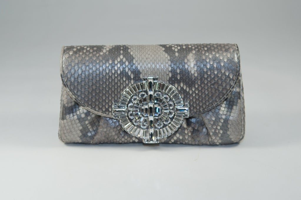 Judith Leiber python evening bag with very large rhinestone clasp in the art deco style. Bag closes by a magnetic clasp that works well and is secure. Lining is purple satin and there is an optional chain. Drop to the top of the bag is about 20