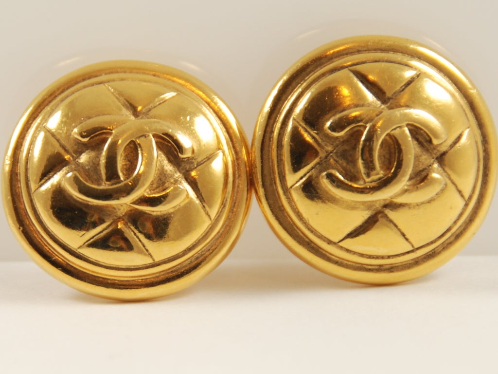 Round, classic gold tone Chanel ear clips in the quilted pattern with interlocking C's. About 1.25
