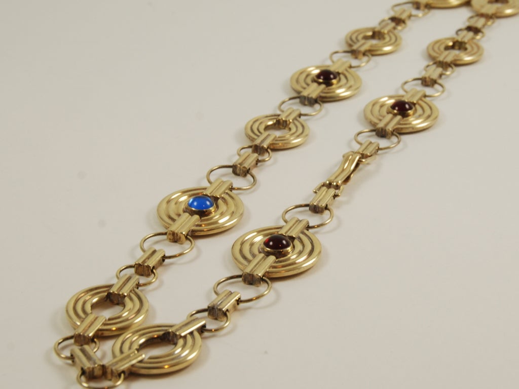 Gilt metal adjustable chain belt with blue and red cabochon stones. Made by the Spanish luxury goods house of Loewe. Can also be worn as a necklace.
