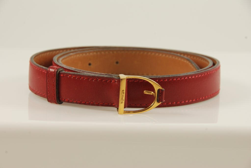 Hermes red leather horse bit belt. This is a narrow belt, 18 mm wide and the Hermes size is a 75. At the last hole the belt is 30.5