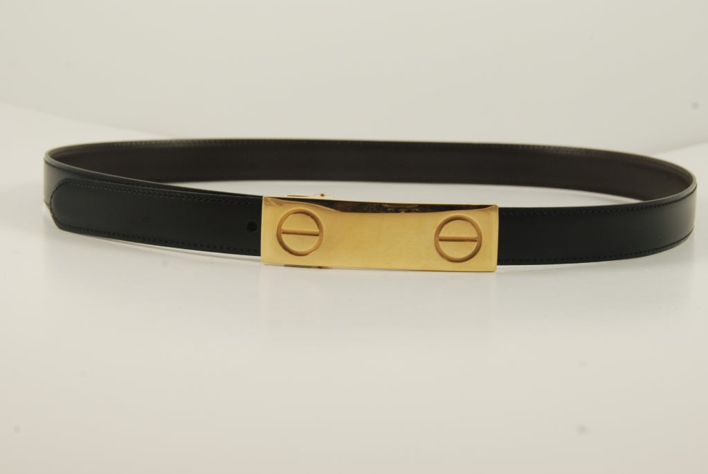 Reversible black and brown Cartier leather belt with large buckle in the motif designed by Cipullo for the famous Cartier love bracelet. Belt is adjustable from 29