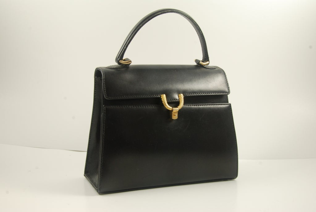Smooth black leather vintage Mark Cross handbag with gold clasp. Bag is probably from the 1970's and has a classic look.

Inside is lined in smooth black leather, has multiple sections, clasp works well and closes securely.

Barney's NY has just