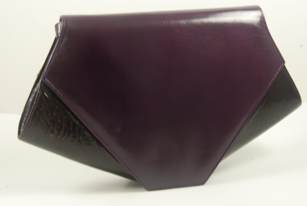 Deco style Charles Jourdan purse in a beautiful eggplant color. It is a combination of smooth and textured leathers. There is an optional strap that snaps into place and has a 22