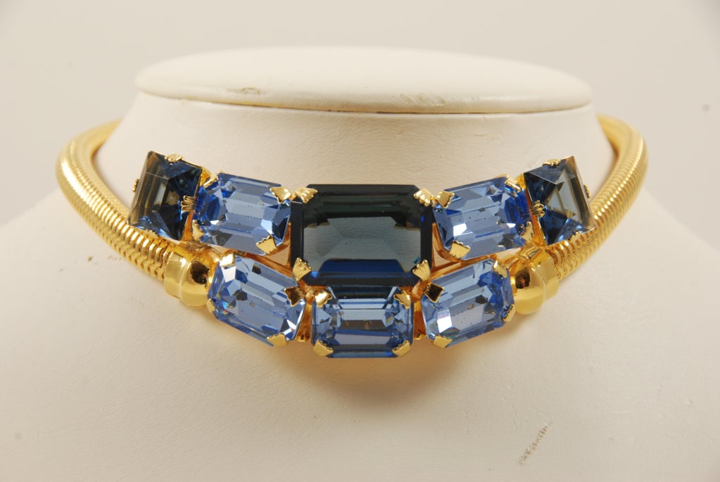 Blue rhinestone choker necklace with gold snake chain sides. Rhinestone are shades of blue and crystal clear. The rhinestones are large. The snake chain and all the metal on this piece was recently been re-plated due to wear of the finish. 

The