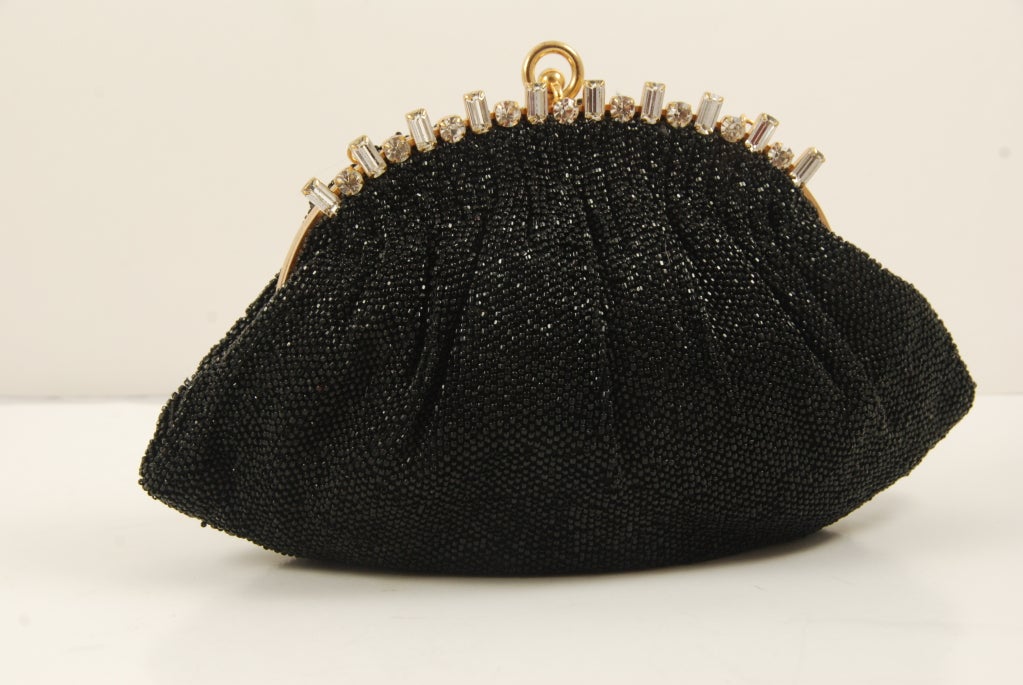 Black beaded evening bag by Josef from the 1950's, made in France. There is a rhinestone frame with clear, sparkling rhinestones.

Clasp works well and closes securely. There is a small hand chain.
Lining is black satin.