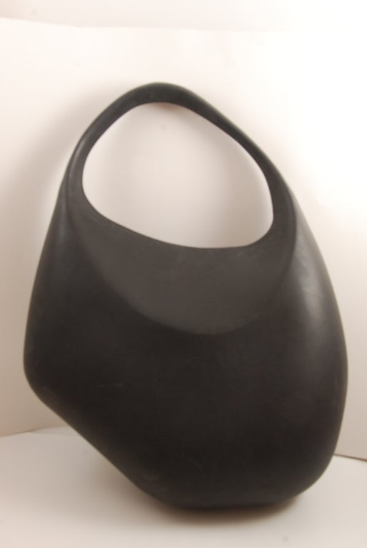 Black molded rubber purse by Thierry Mugler. Closure is two chrome balls that fit into rubber sockets that are only seen if the purse is open. Asymmetrical design. 

Handle drop to top of bag 6
