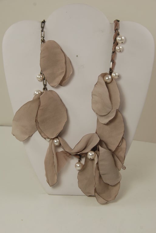 Lanvin petals necklace made in France.  Necklace has silk petals in a taupe color, glass pearls and silk woven through parts of the blackened metal chain. Spring ring closure.