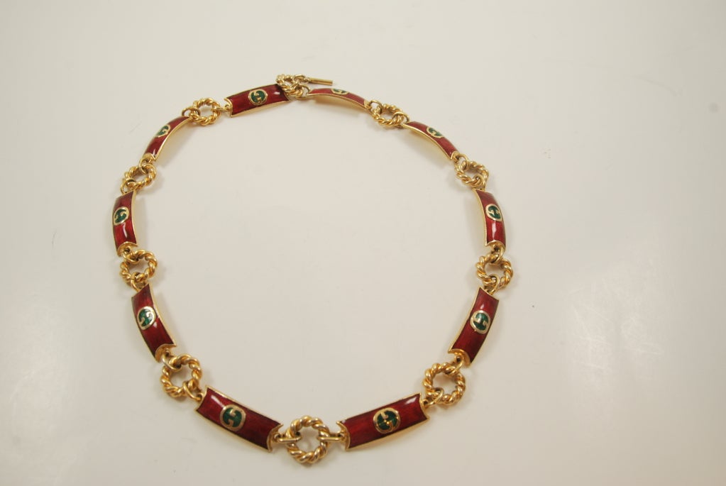 Gucci chain link and enamel bar necklace. Each bar has the Gucci logo. The field color of each bar is the red enamel and the G's are in gold and filled in in green. Classic Gucci of the late 1960-70's.  Closure is by toggle clasp.