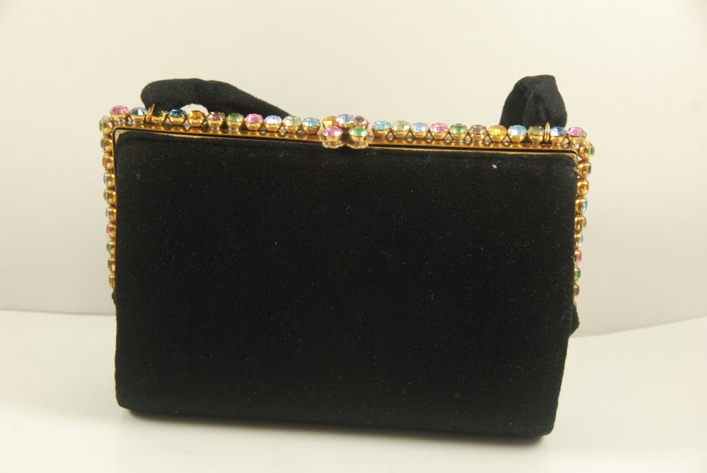 Josef evening bag from the 1940's-50's with a rhinestone studded frame. The stones are in pink, blue, yellow, green,  and lilac. There is a black felt handle that has a 6.5