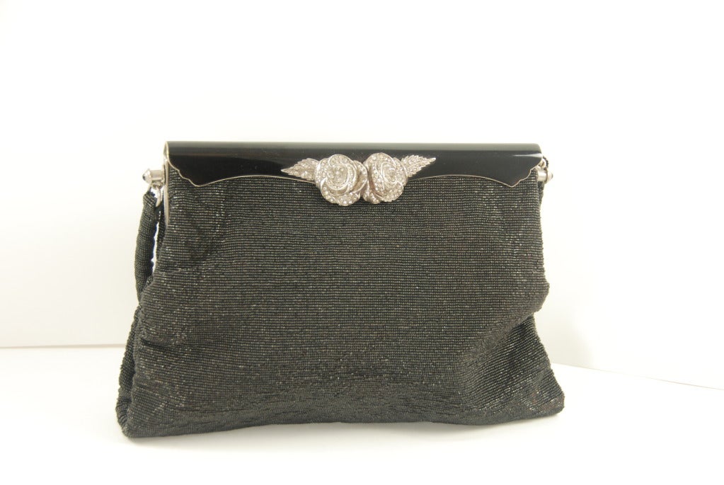 Vintage black steel beaded evening bag  from Paris with enamel frame and a silver and rhinestone floral adornment. All the beads are black but beads with two different finishes were used to give a subtle art deco style pattern on the front of the