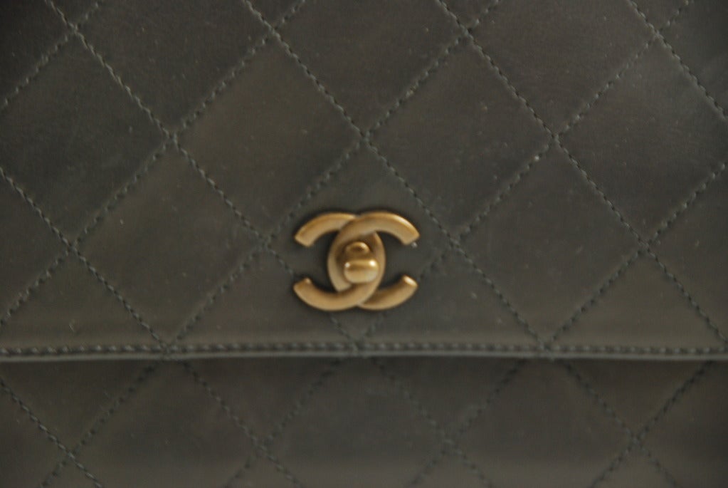 Chanel quilted black lambskin handbag in a trapezoid shape. The strap on this bag has an 8