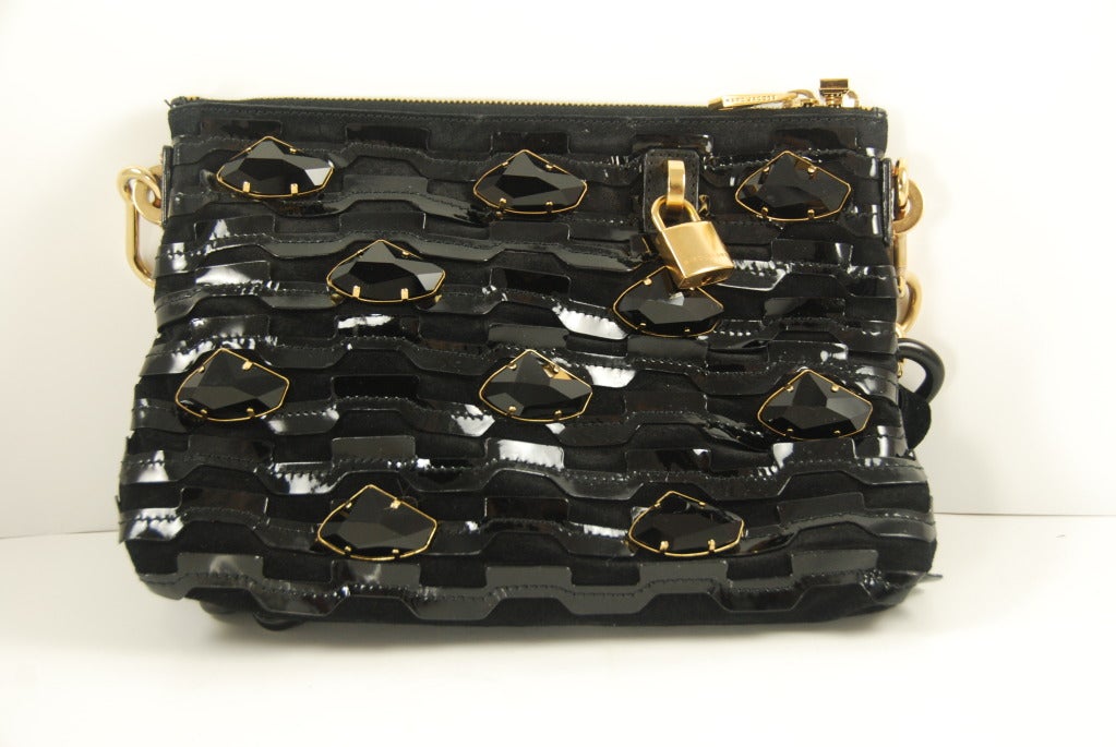 Interesting patent leather over black suede cut work purse studded with large black jet rhinestones. The layering of different textures gives this bag a subtle yet lively appearance without overdoing the bling. The removable shoulder strap has a