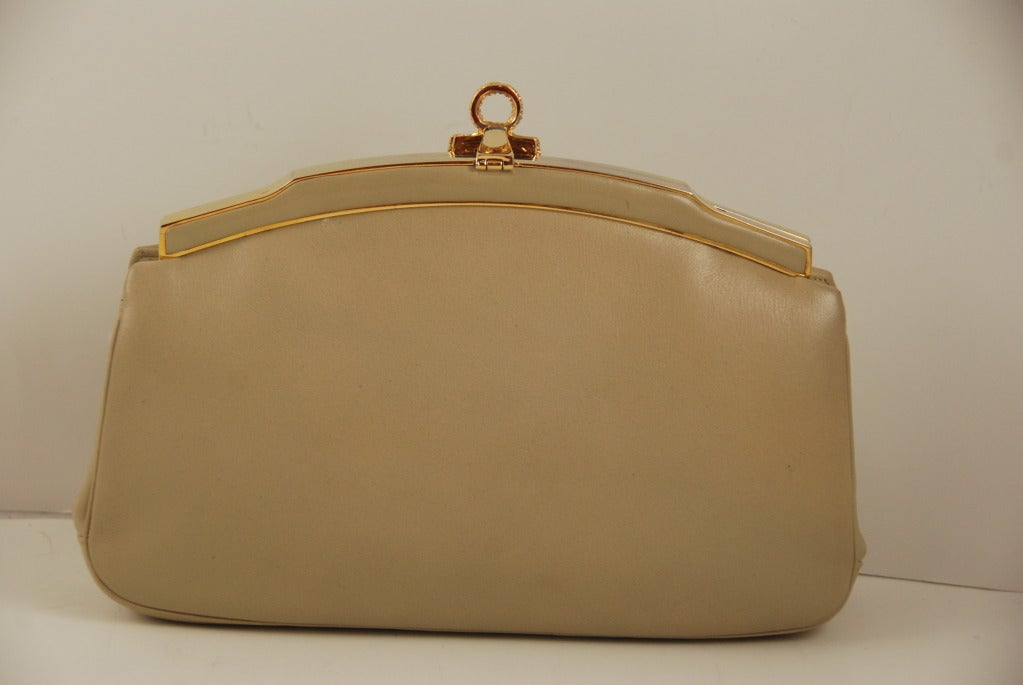 Simple yet elegant Judith Leiber handbag fro the 1990s.  Color as always is hard to describe but it is a dark tan to dark khaki color leather handbag that can be used as a clutch or shoulder bag. The great thing about the color is that it is great