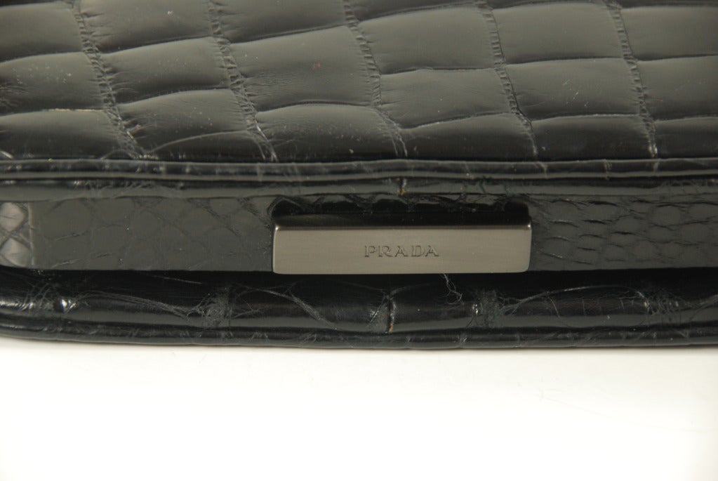 Prada black alligator shoulder bag. Bag has one main compartment and one zipper compartment. Latch works well and bag closes securely. Strap has a 9.5