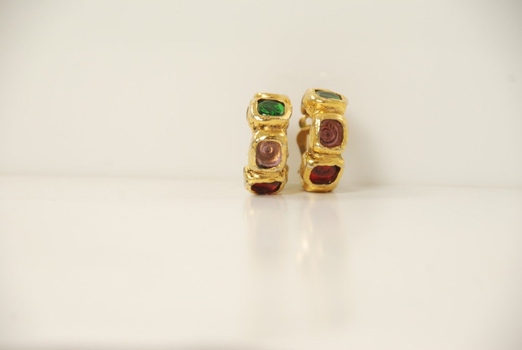 Chanel hoop earrings from the 1970s-80s. The metal is burnished gold tone and the gripoix glass is in green, red and amethyst. Each earring has 5 stones that go all around the earring. These are clip on hoops.