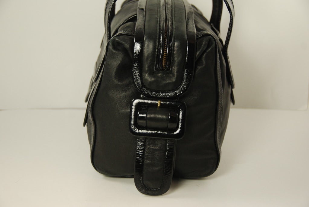 Black lambskin leather handbag with patent leather trim by Pierre Hardy. Before going out on his own Hardy was a designer for Balenciaga and Hermes. This bag is of the highest quality and retailed by Bergdorf Goodman. There is an outside compartment