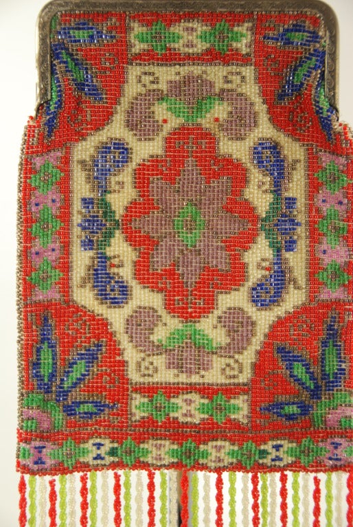 Beaded bag from the 1920s in remarkable condition. The beads are all intact, including the fringe which is rare in a bag of this age. The inside lining is almost all gone from fraying. The bag can be relined. The frame is silver colored and is made