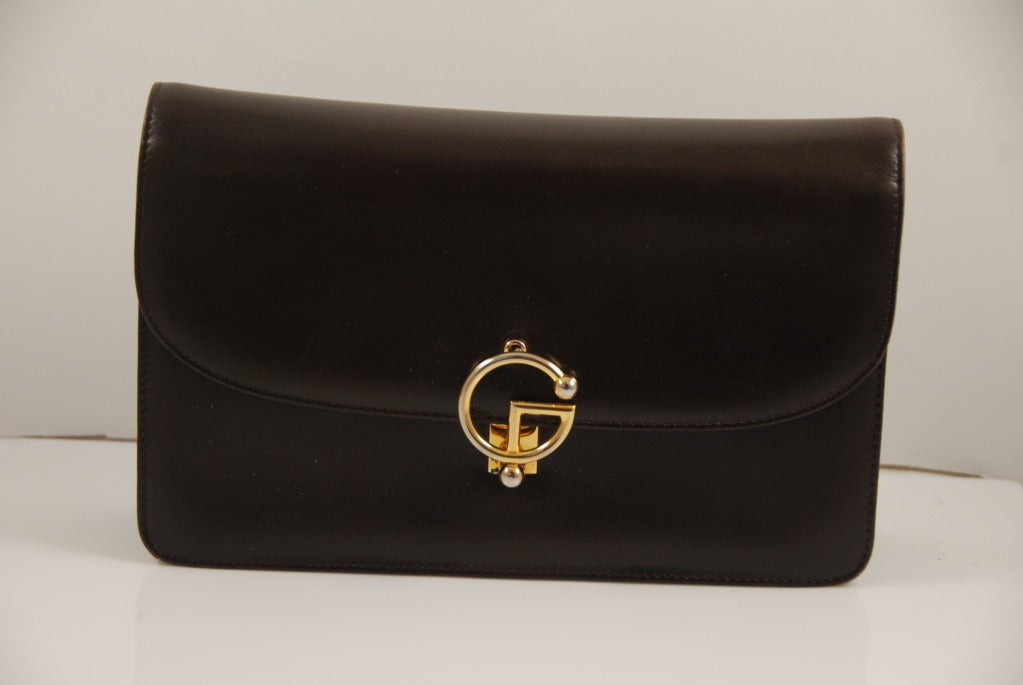 Brown leather Gucci handbag from the 1970s. The leather is of the highest quality,and smooth to the touch, inside and out. The decorative clasp on this bag is fabulous. Made of brass it is a stylized 