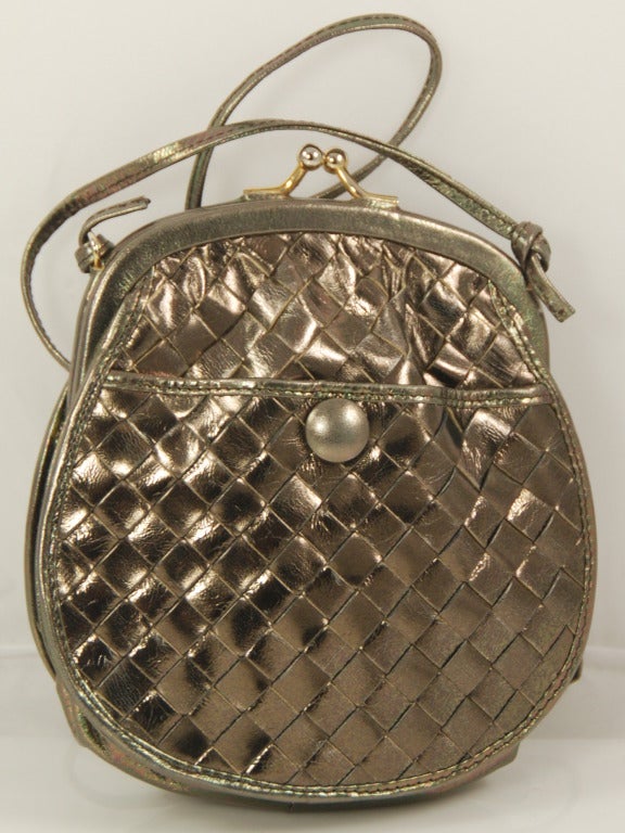 Fun little Bottega Veneta metallic bronze intrecciato cross-body purse. This little gem is from the 1980s. Closes with a kiss lock clasp that works well. There is an outside compartment that has a snap closure.