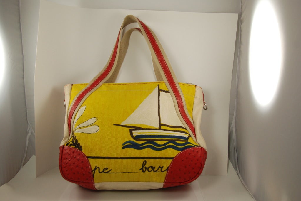 This bag is perfect for the Hamptons, Palm Beach or where ever you go to play. Large tote with red ostrich corners and trim and a sailing scene on the front and back. Inside the seams are piped in red leather as well. There is also a zipper