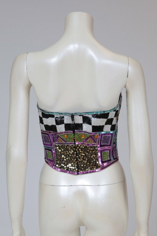 Stunning multicolor sequined and beaded evening corset top from the eighties. The corset is lined and boned, fastening at the back with a zip & a hook.

Fits approx. : US 2-4 / FR 36

Measurements (taken flat) :
Waist approx. 33 cm (13