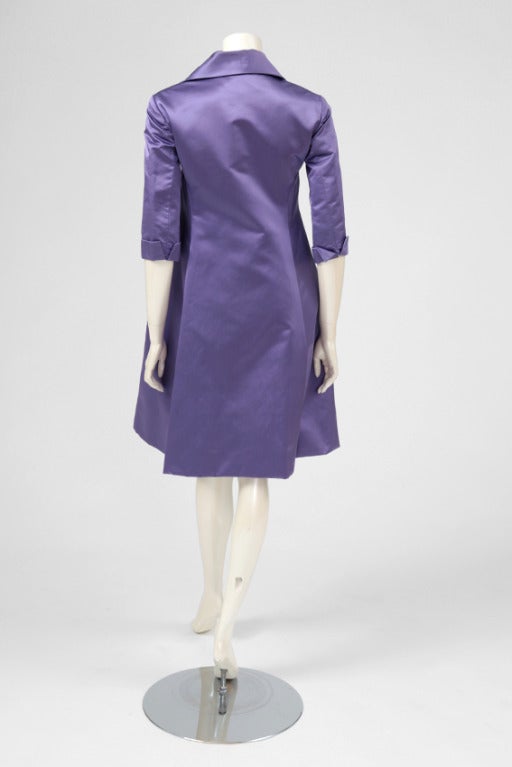 Seltener und schöner 50er Jahre Haute Couture Mantel / Kleid aus fliederfarbenem Duchesse-Satin.

Passt ca. : US 2-6 (klein US 6) / FR 36-38 

Abmessungen (flach gemessen) :
Breite (knapp unter der Brust gemessen) ca. 80 cm (31,5 Zoll)
Breite