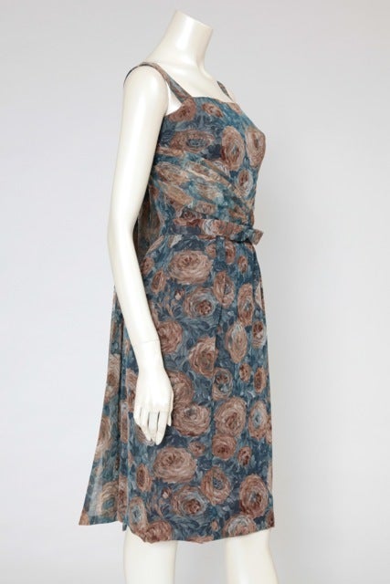 End of fifties-early sixties organza floral print dress attributed to Hubert de Givenchy. Train-cape in the back, matching bow belt and refined draped bustier. The dress fastens at the back with a concealed zip, hook and eye.

Fits approx. : US 0-4