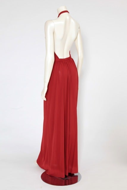 Burnt orange long jersey halter gown dating from the seventies. Non detachable long silk-fringed scarf & two side pockets. The gown closes on the left side with a zip & a hook.

Fits approx. : US 2-6 (small US 6) / FR 36-38 

Measurements (taken