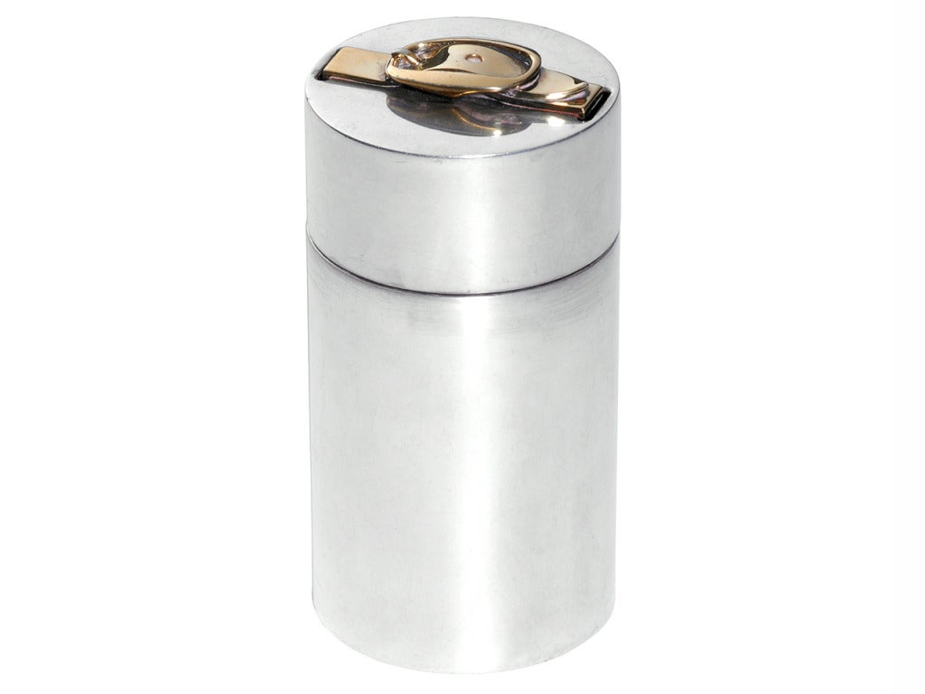 A Solid Silver Hermès Table Lighter - a stamped Collector’s piece - a must have for classy living. 
It has a gold-tone metal buckle, a symbol of the house Hermès, on the top. Made in France. Function currently out of use. Sold with its dust bag.