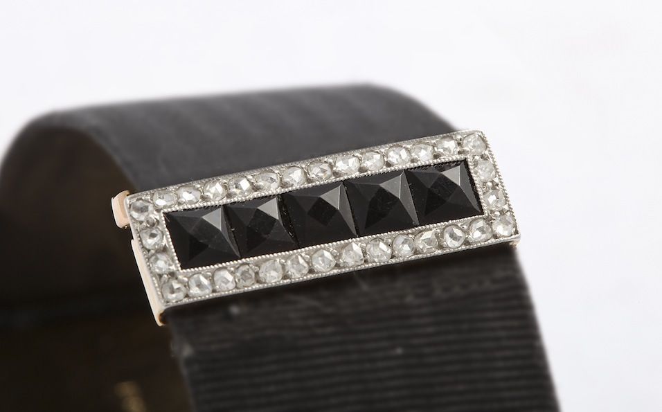 A very rare Cartier Paris ladies watch set with rose diamonds and calibre cut onyx. The silk moire band has the most unusual original matching calibre cut onyx and diamond set buckle deployant. Movement is European Watch & Clock Co. Most of these