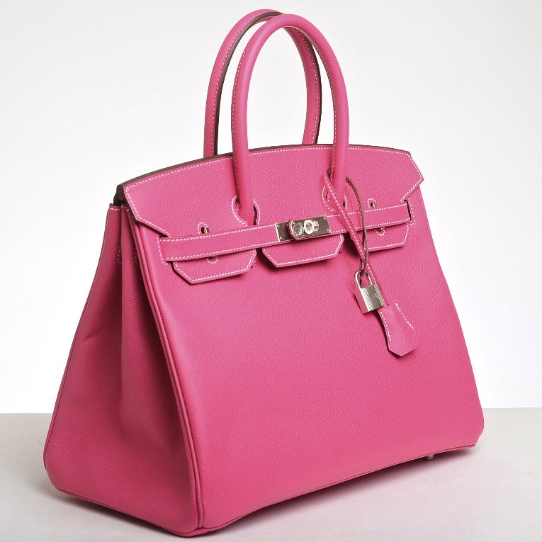 Hermes Rose Tyrien Birkin 35cm in epsom leather with palladium hardware.

The Hermes Birkin is the most coveted and the hardest to acquire handbag in the world. Immediately recognizable by its shape, its thin straps with metal plates on the end of