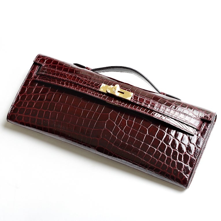 Hermes Bordeaux shiny niloticus crocodile Kelly Cut clutch with tonal stitching, gold hardware, front straps with toggle closure and top flat handle.

Collection: Q square (2013)

Origin: France

Condition: Never Carried

Accompanied by: